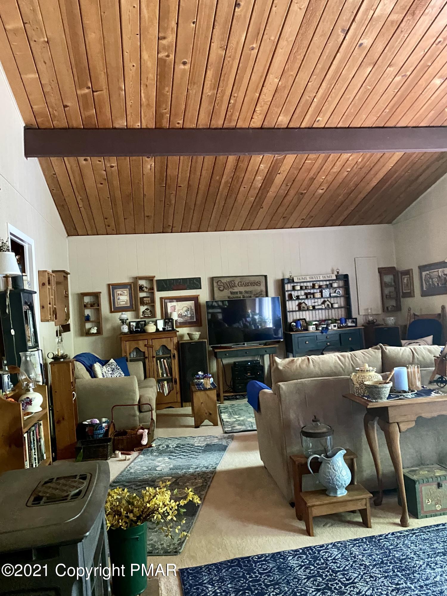 155 Chipmunk Road Bushkill, PA 18324 - Photo 10 of 18 a living room with lots of furniture and gym equipment