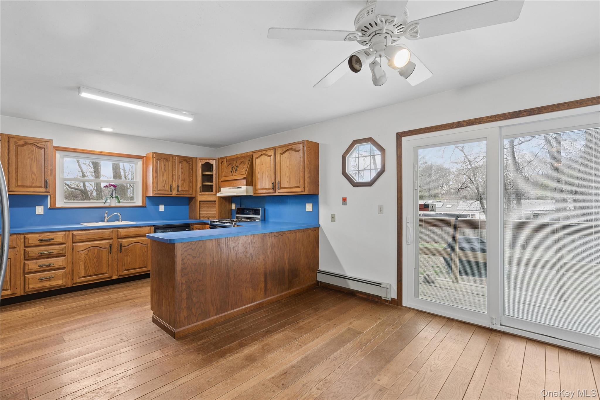 49 Overhill Road Wading River, NY 11792 - Photo 9 of 27 a kitchen with stainless steel appliances granite countertop a refrigerator a stove a sink and dishwasher with wooden floor