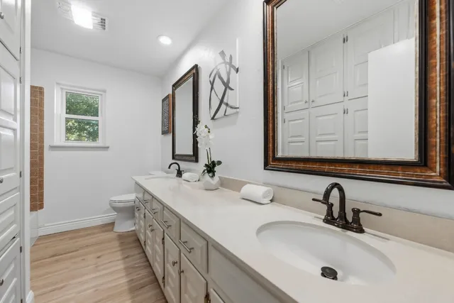 a bathroom with double vanity and a mirror