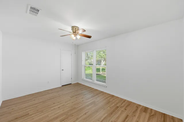 wooden floor in an empty room with a window