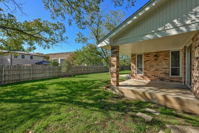 a view of a house with backyard and sitting area