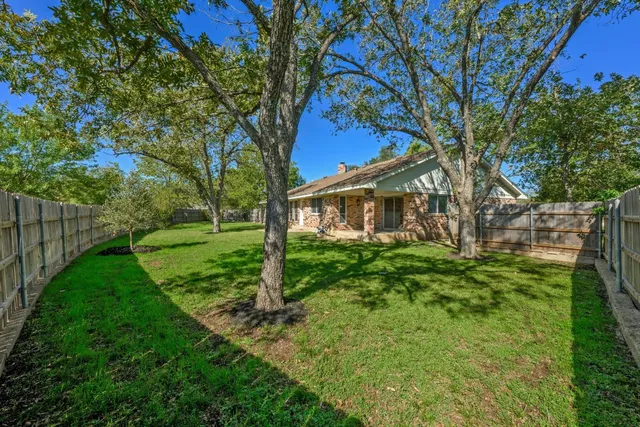 a view of a house with yard and a tree