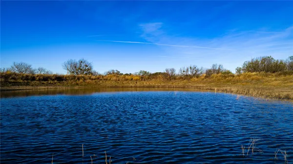 a view of lake with boats and trees in the background