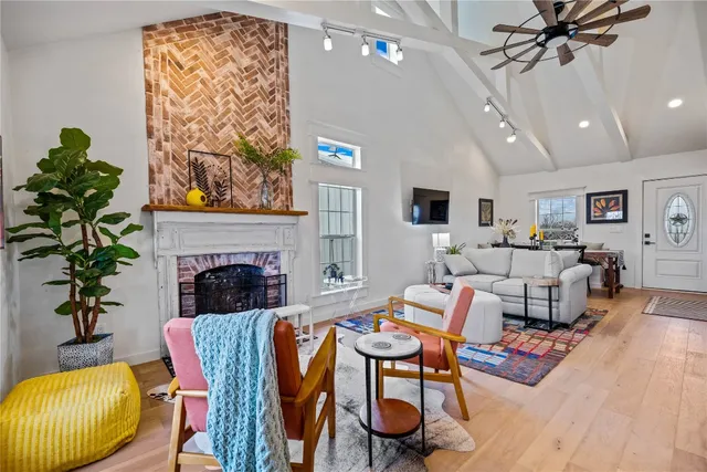 a kitchen with stainless steel appliances kitchen island granite countertop a sink dishwasher a dining table and chairs with wooden floor