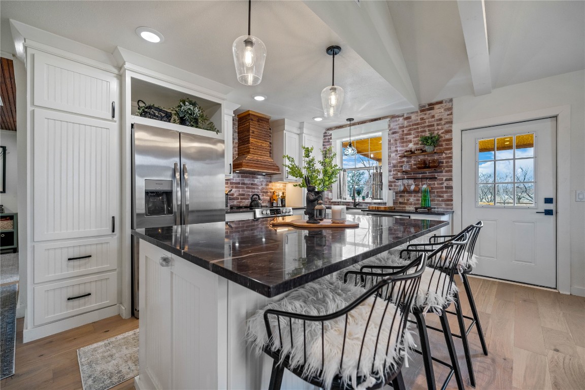 126 Buffalo Rd Valley Spring Valley Spring, TX 76885 - Photo 6 of 39 a kitchen with stainless steel appliances kitchen island granite countertop a table chairs in it and wooden floors
