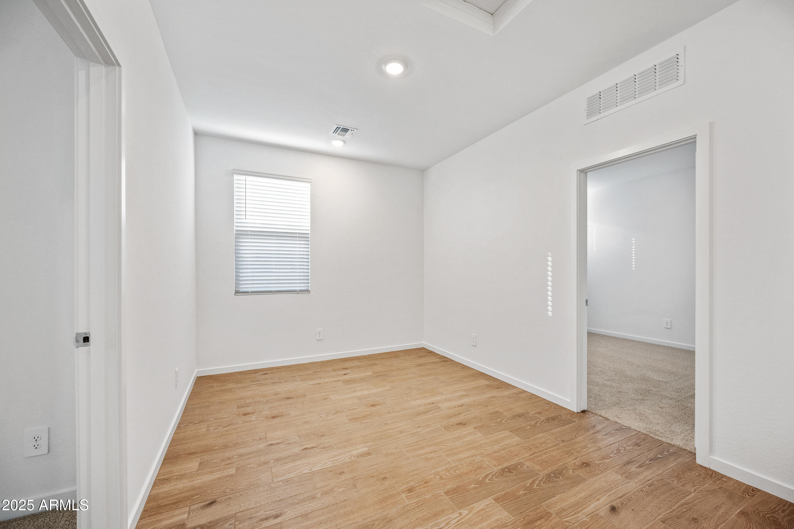 15825 West Gray Fox Trail Surprise, AZ 85387 - Photo 22 of 38 an empty room with wooden floor and windows