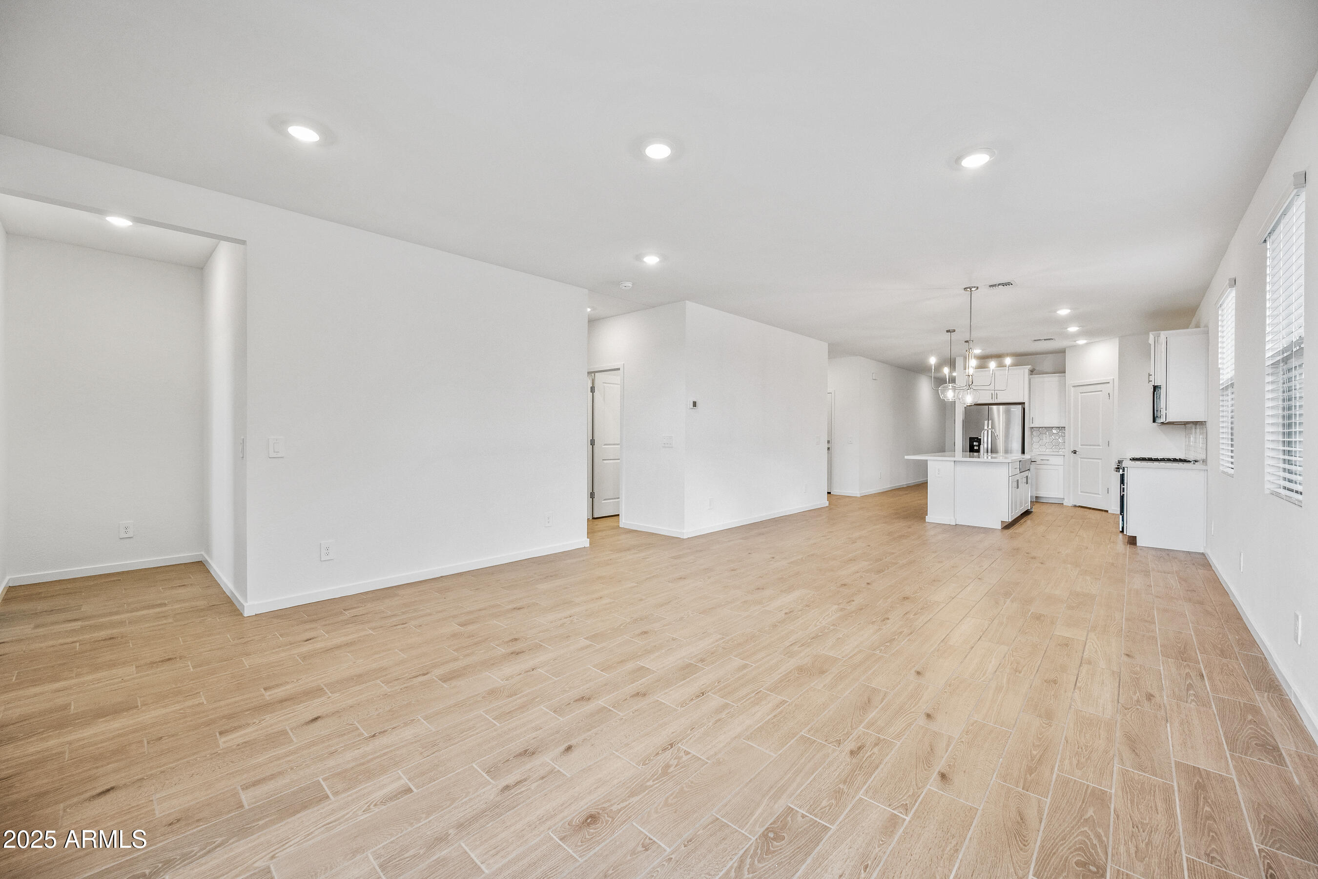 15825 West Gray Fox Trail Surprise, AZ 85387 - Photo 5 of 38 a large white room with kitchen natural light and wooden floor