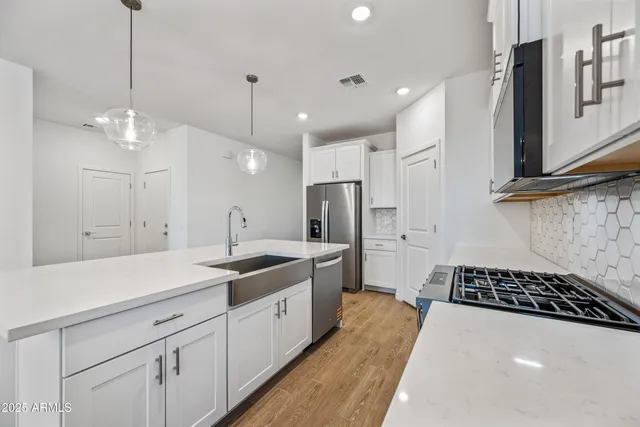a kitchen with a sink stainless steel appliances and cabinets