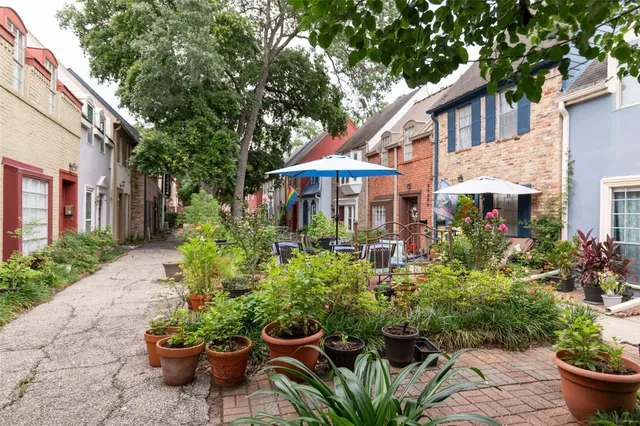 a front view of a house with a yard and potted plants