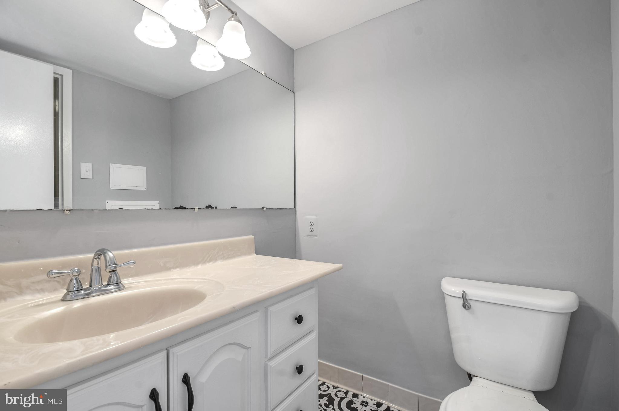 1836 Metzerott Road, Unit 925 Hyattsville, MD 20783 - Photo 14 of 33 a bathroom with a toilet a sink and mirror