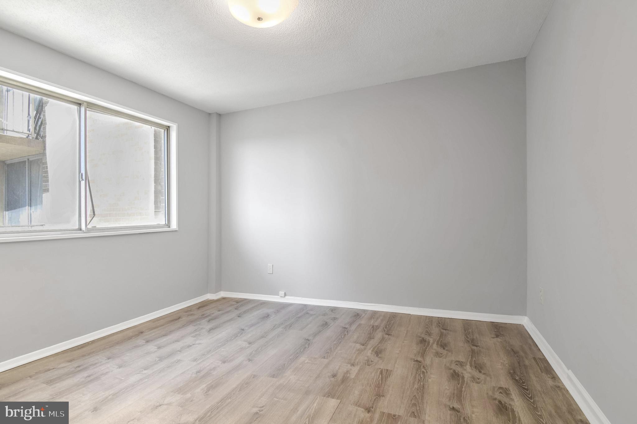 1836 Metzerott Road, Unit 925 Hyattsville, MD 20783 - Photo 21 of 33 a view of an empty room with wooden floor and a window