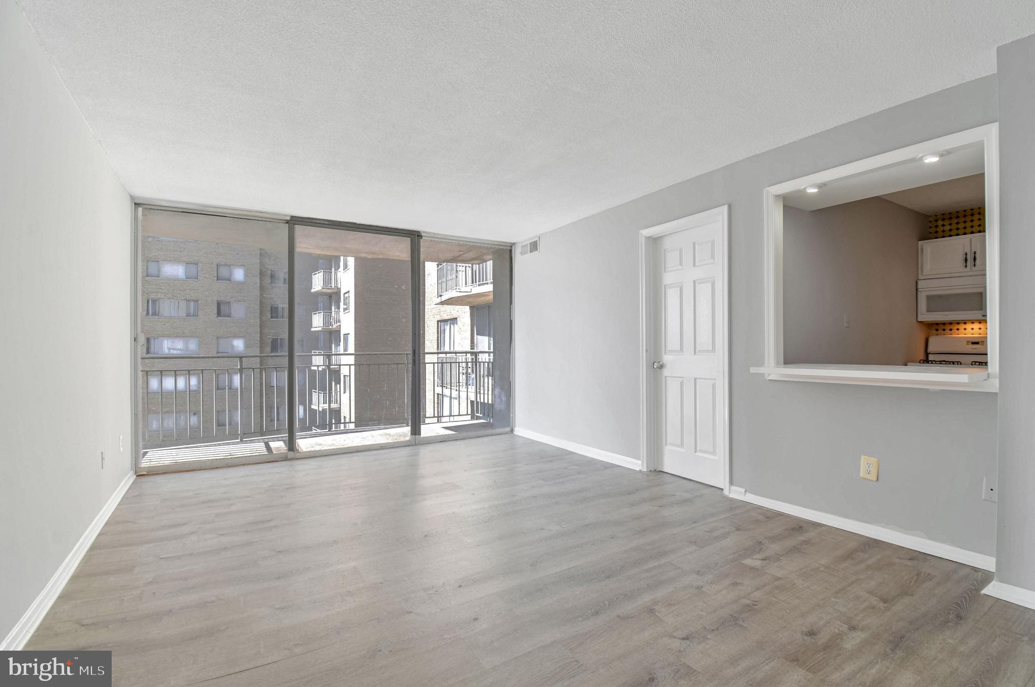 1836 Metzerott Road, Unit 925 Hyattsville, MD 20783 - Photo 6 of 33 an empty room with wooden floor and windows