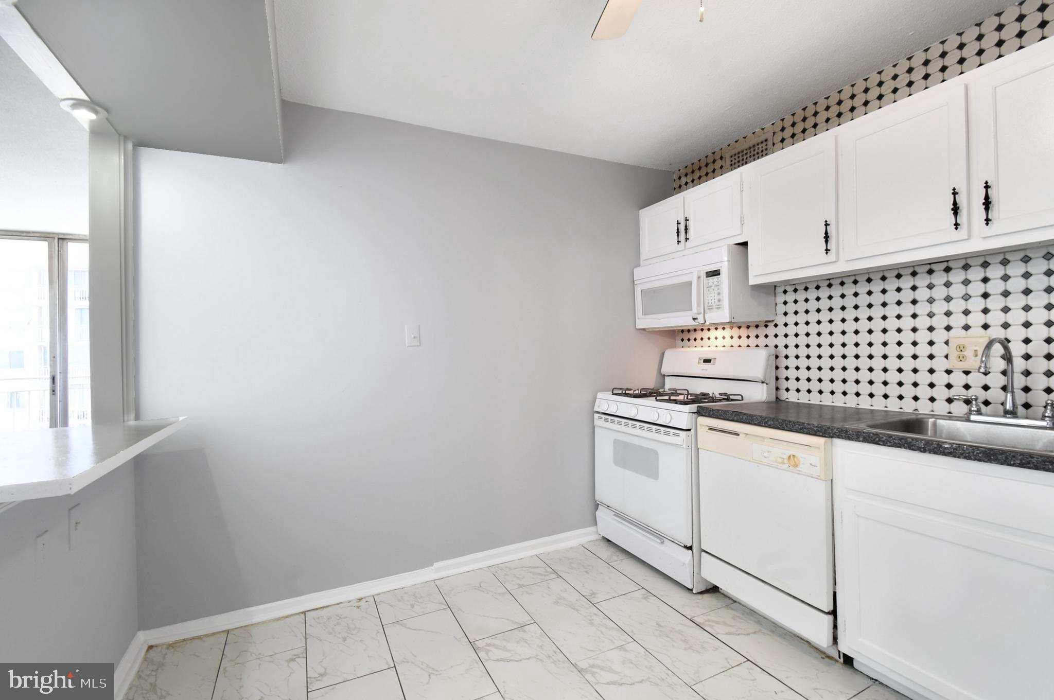 1836 Metzerott Road, Unit 925 Hyattsville, MD 20783 - Photo 8 of 33 a kitchen with granite countertop white cabinets and white appliances