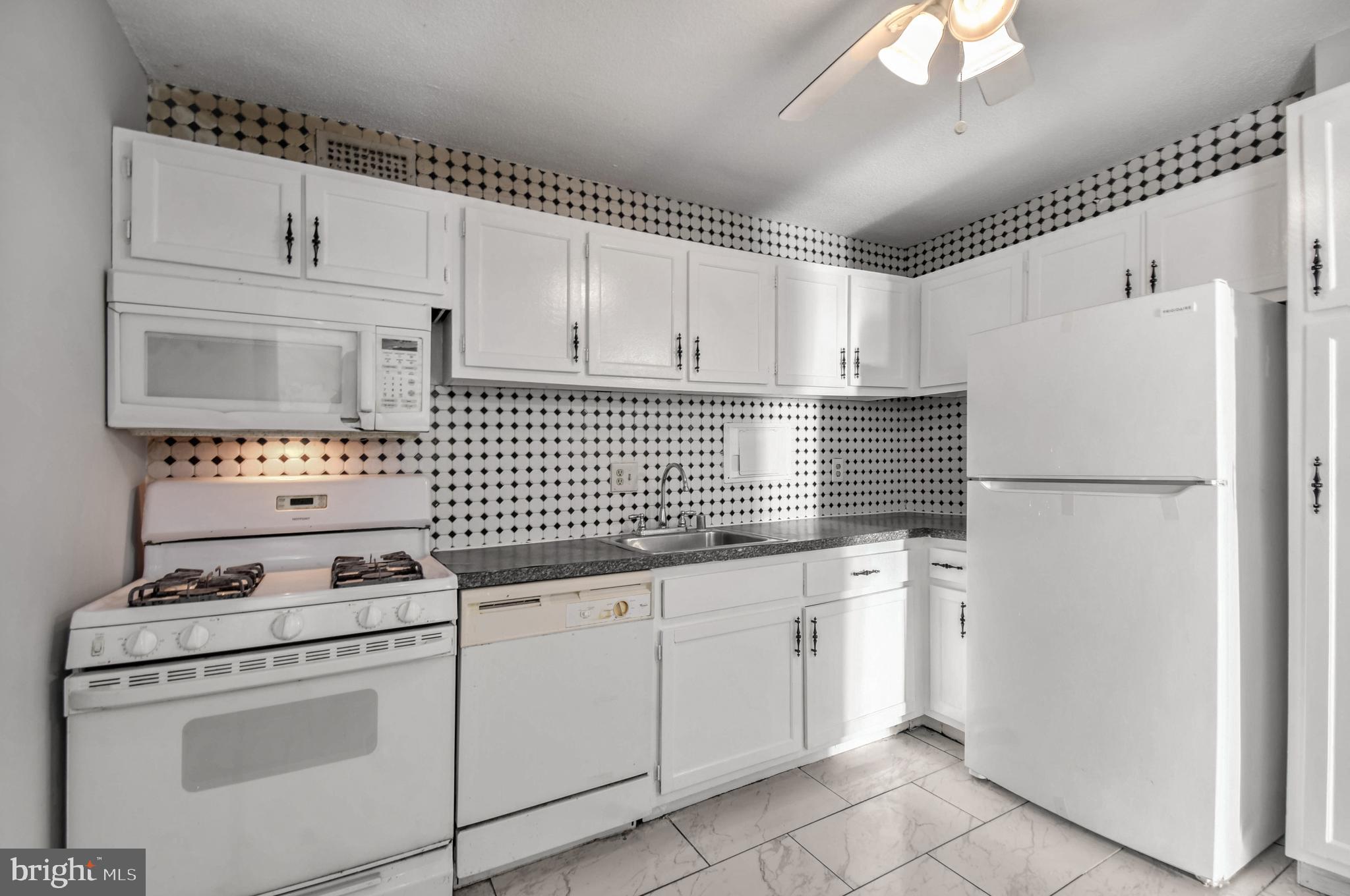 1836 Metzerott Road, Unit 925 Hyattsville, MD 20783 - Photo 9 of 33 a kitchen with granite countertop white cabinets and white appliances
