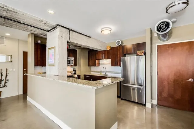 a kitchen with stainless steel appliances granite countertop a refrigerator and a sink