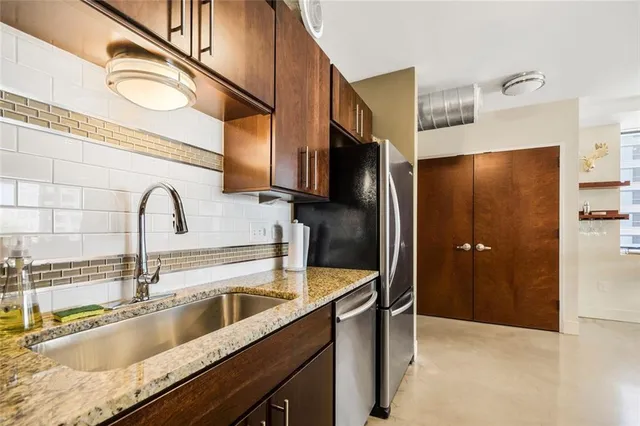 a kitchen with stainless steel appliances granite countertop a sink stove and refrigerator