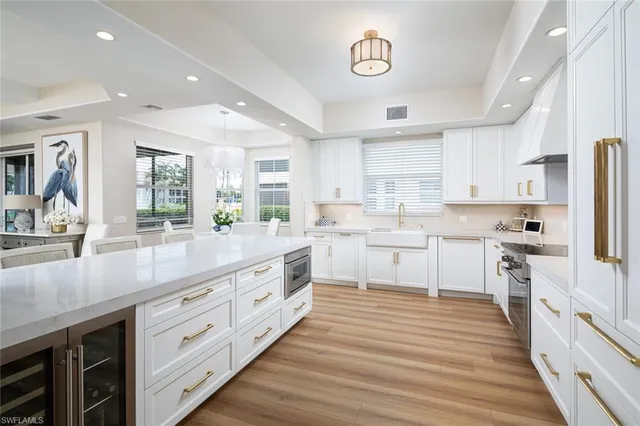 a kitchen with white cabinets stainless steel appliances and sink