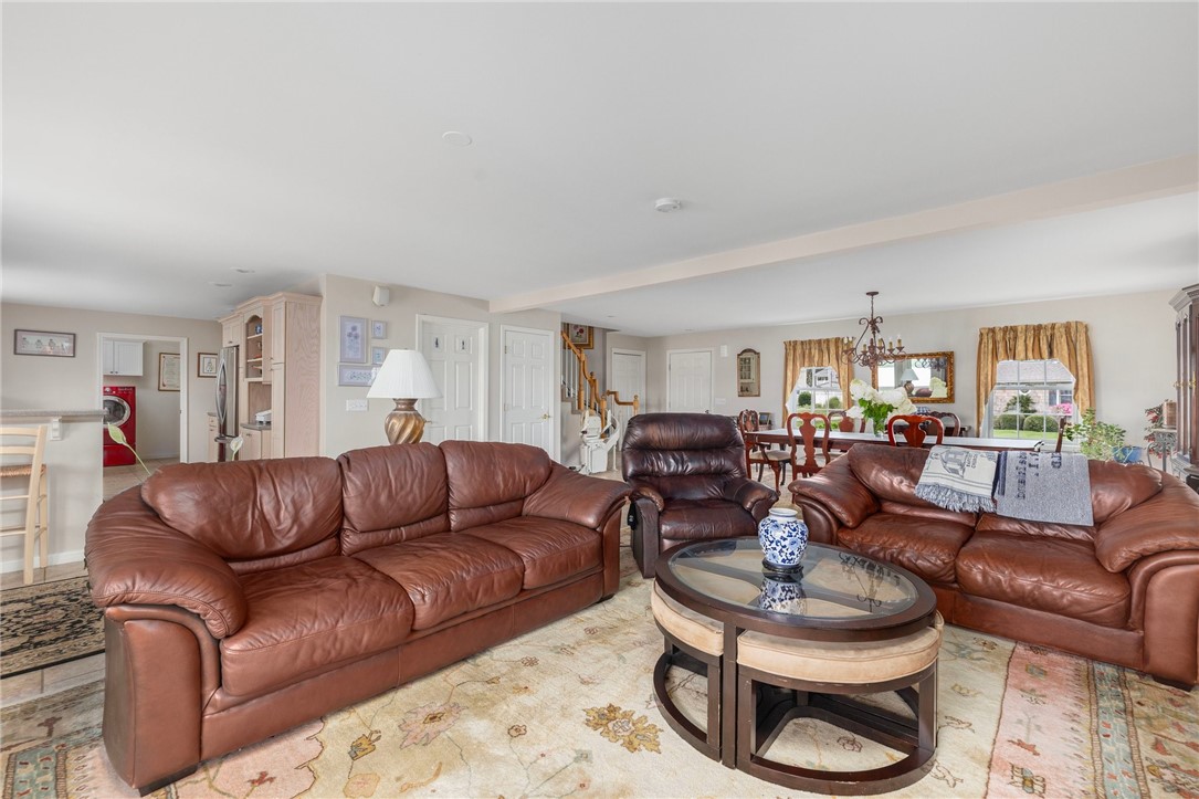 69 East Shore Road Narragansett, RI 02882 - Photo 13 of 42 Photo showing front door (far end of photo) with stairs to second level and showing kitchen and pantry/laundry beyond the living room
