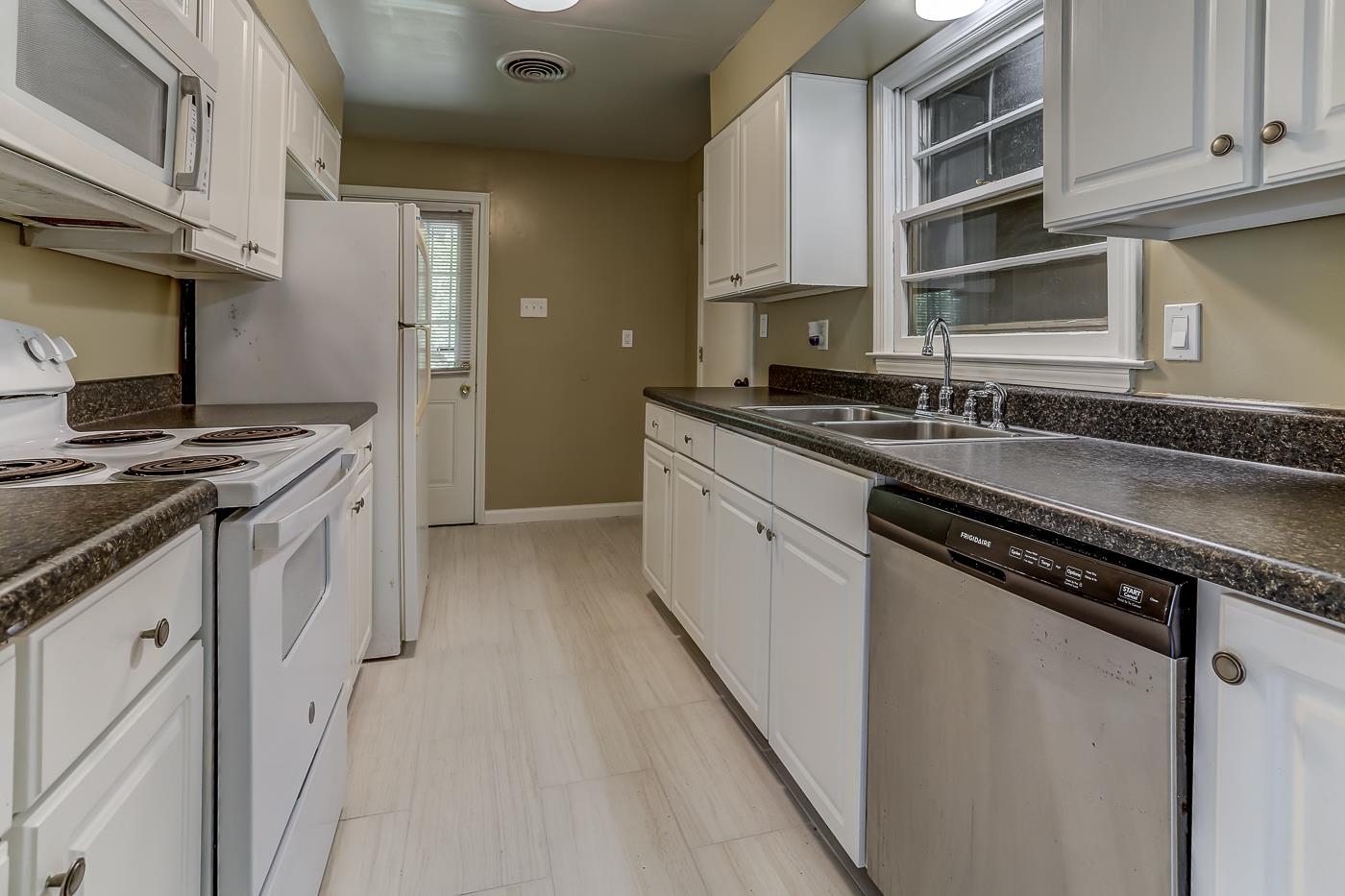 1787 Dearing Road Memphis, TN 38117 - Photo 2 of 26 Kitchen featuring sink, light tile patterned floors, white cabinets, and white appliances
