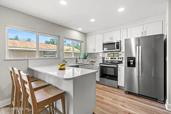 a kitchen with refrigerator cabinets and wooden floor