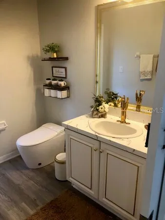 a bathroom with a sink toilet and a mirror