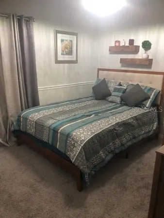 a bedroom with a bed and lamp