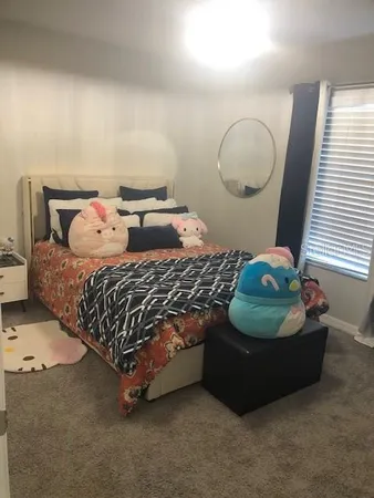 a bed sitting in a bedroom next to a lamp