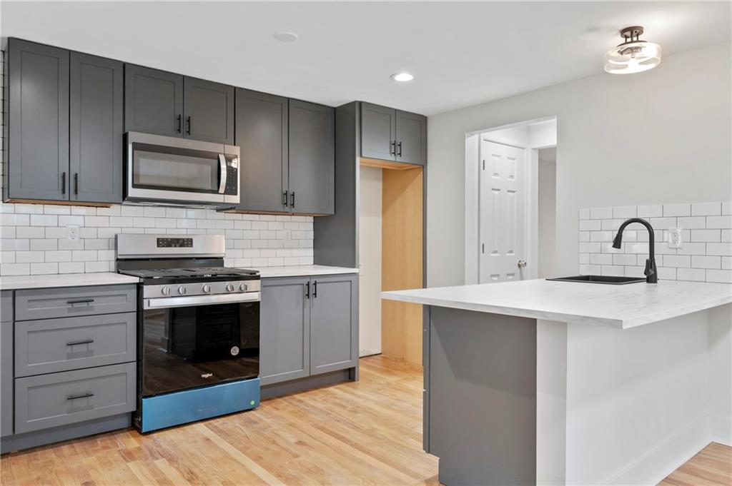 806 Ridge Avenue McKees Rocks, PA 15136 - Photo 16 of 30 a kitchen with stainless steel appliances granite countertop a stove a sink and a microwave