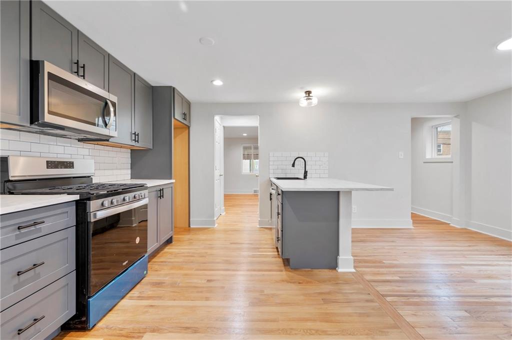 806 Ridge Avenue McKees Rocks, PA 15136 - Photo 19 of 30 a large kitchen with stainless steel appliances granite countertop a stove and a wooden floors