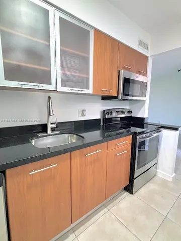 a kitchen with stainless steel appliances granite countertop a sink stove and microwave