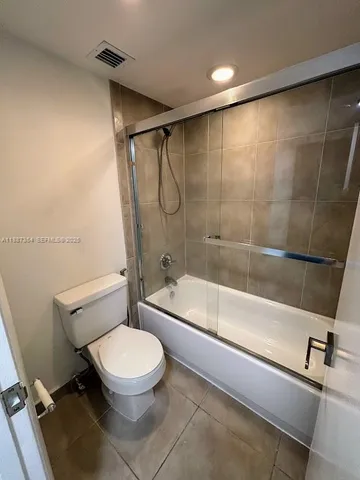 a bathroom with a toilet and a bath tub