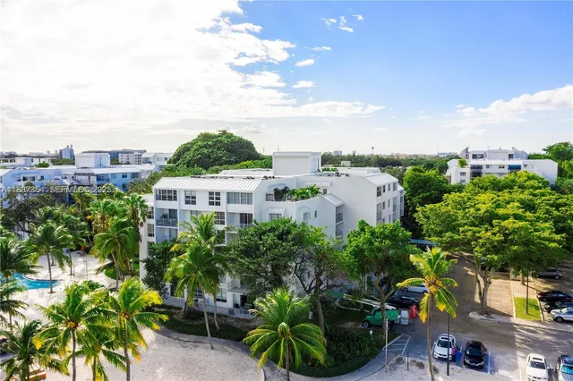 a view of a large yard with plants and large trees