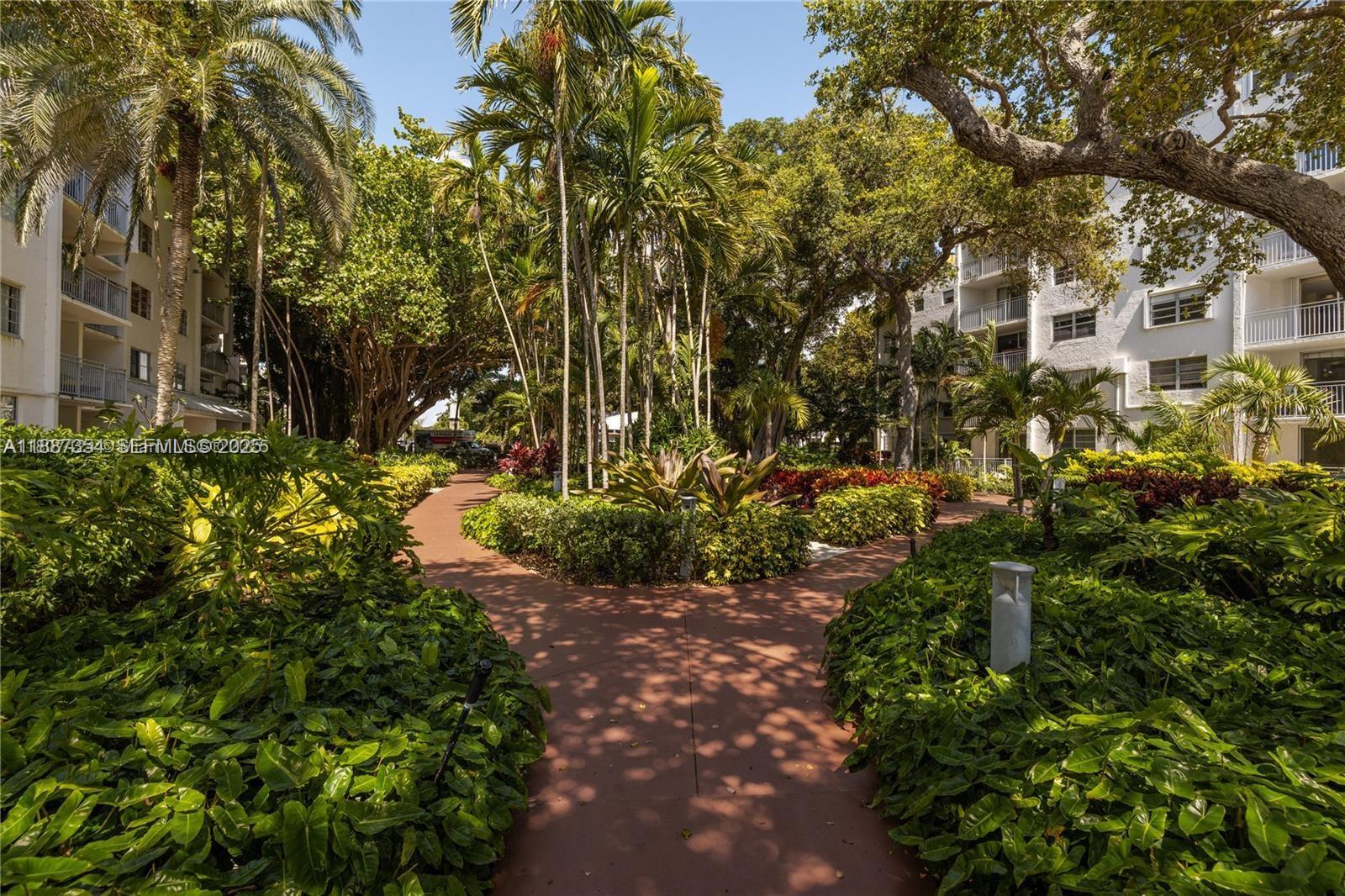 680 Northeast 64th Street, Unit A516 Miami, FL 33138 - Photo 20 of 54 a view of a large yard with plants and large trees