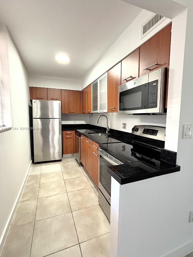 680 Northeast 64th Street, Unit A516 Miami, FL 33138 - Photo 2 of 54 a kitchen with a stove a microwave and a refrigerator