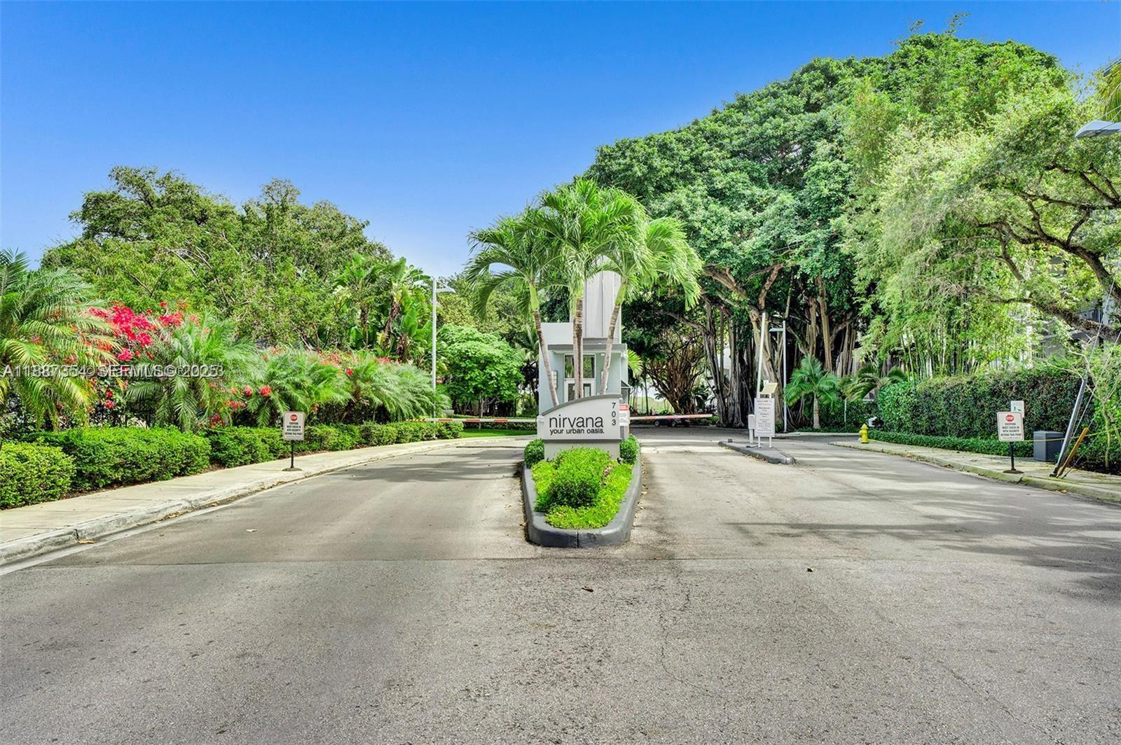 680 Northeast 64th Street, Unit A516 Miami, FL 33138 - Photo 23 of 54 a road view with large trees