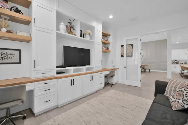 a large white room with furniture and flat screen tv