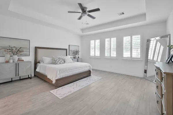 a bedroom with a bed chandelier and window