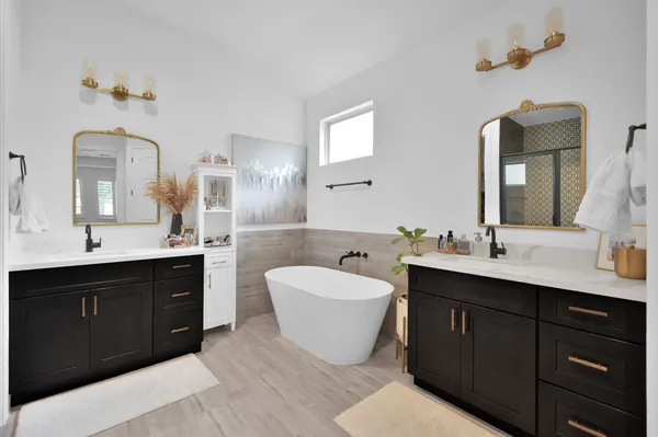 a bathroom with a double vanity sink mirror and bathtub