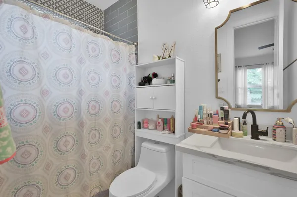 a bathroom with a toilet sink vanity and mirror