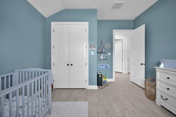 a view of a bedroom with wooden floor