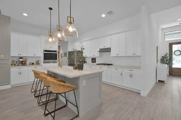 a kitchen with kitchen island granite countertop a sink a center island and cabinets