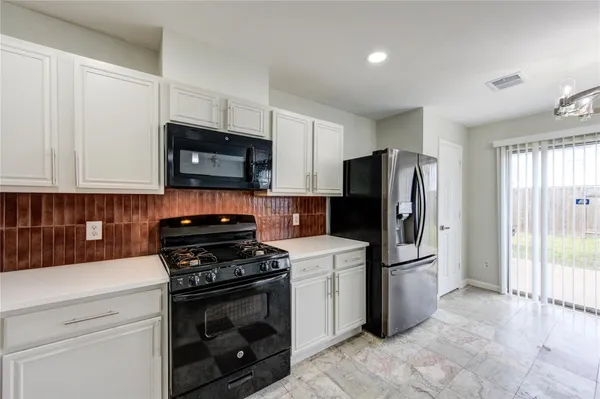 a kitchen with a refrigerator stove and microwave