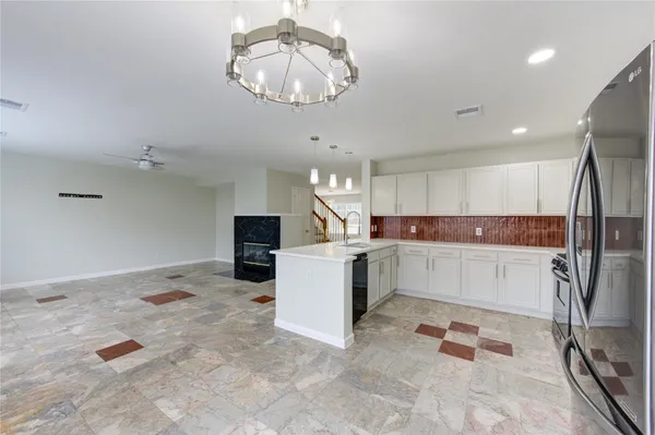a kitchen with a refrigerator and a chandelier