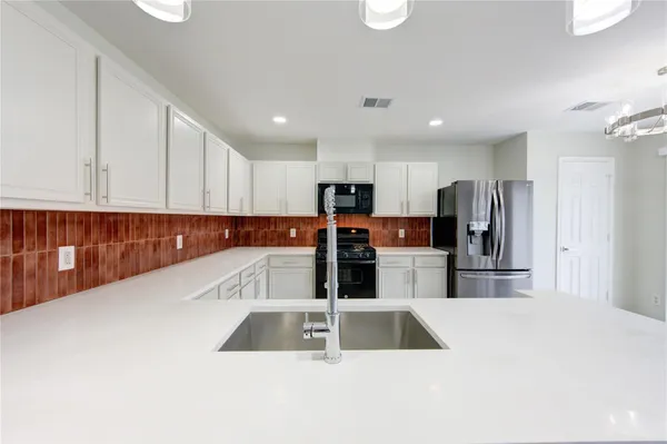 a kitchen with stainless steel appliances a sink and a refrigerator