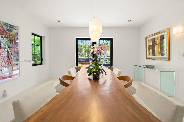 a dining room with furniture a chandelier and wooden floor