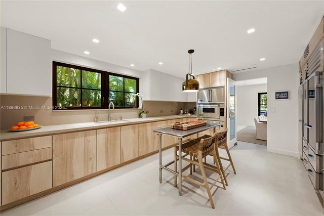 a kitchen with stainless steel appliances kitchen island granite countertop a sink stove and refrigerator