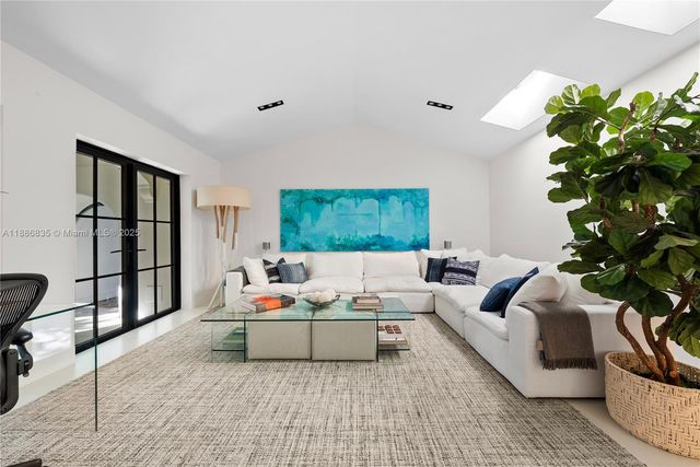 a living room with patio furniture and a potted plant