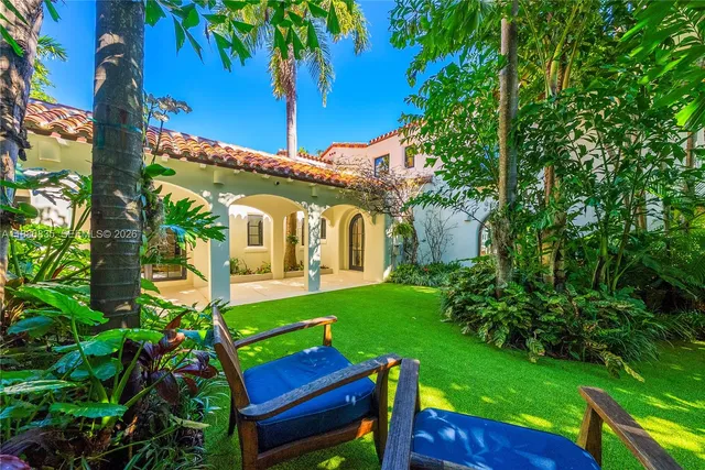 a view of a wooden chairs and table in the garden