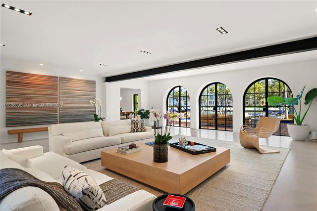 a living room with furniture and three windows