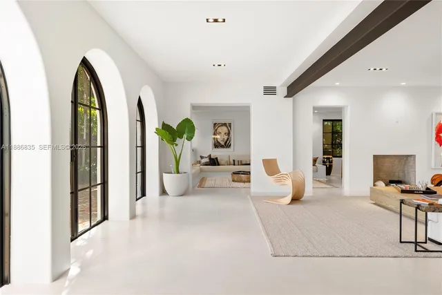a living room with furniture a potted plant and a large window